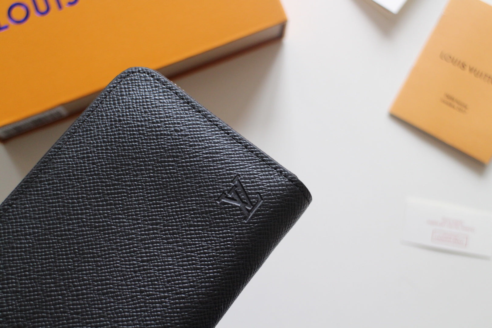 Louis Vuitton small black textured leather bag with embossed LV logo