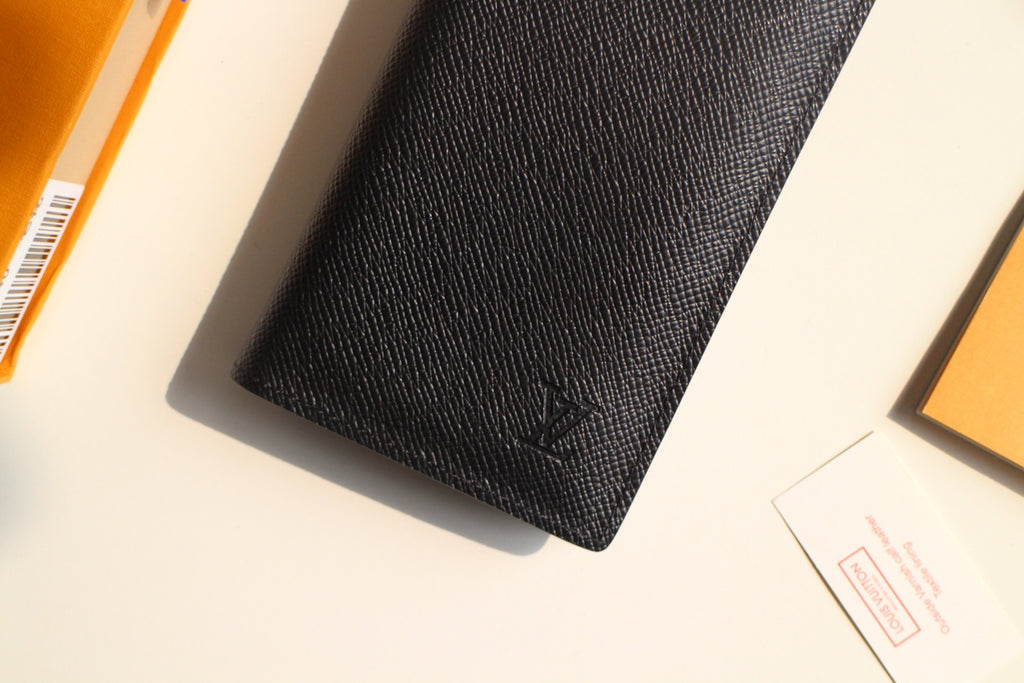 Small Louis Vuitton black textured cardholder close-up with embossed LV logo