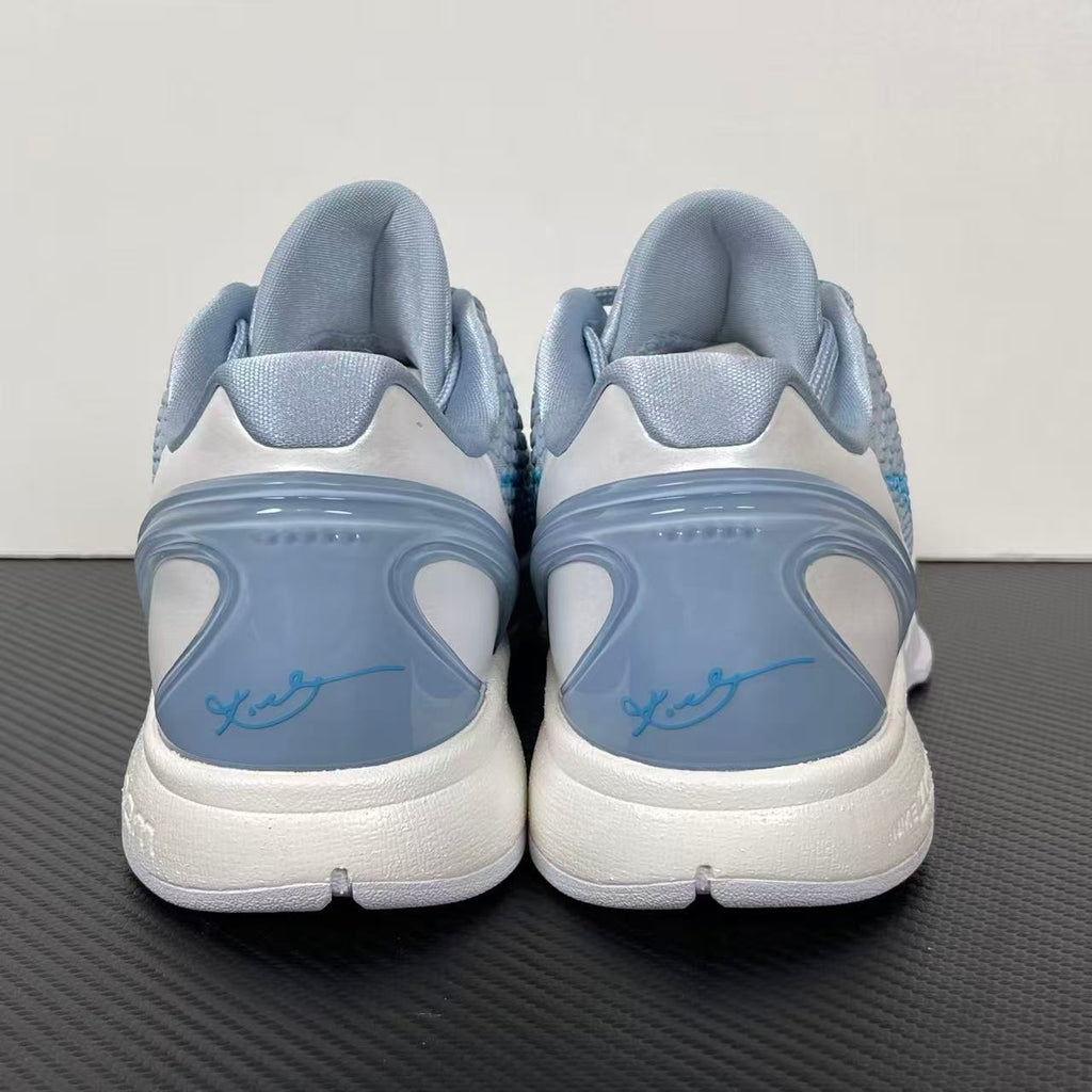 Pair of light blue and gray basketball shoes with white heel, padded back, lace-up.