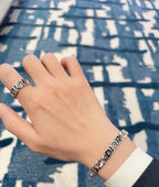 Silver-tone DIOR link bracelet on wrist, stacked chain segments with DIOR branding