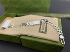 Silver chain bracelet with white leather strap and Gucci web stripe detail, side view