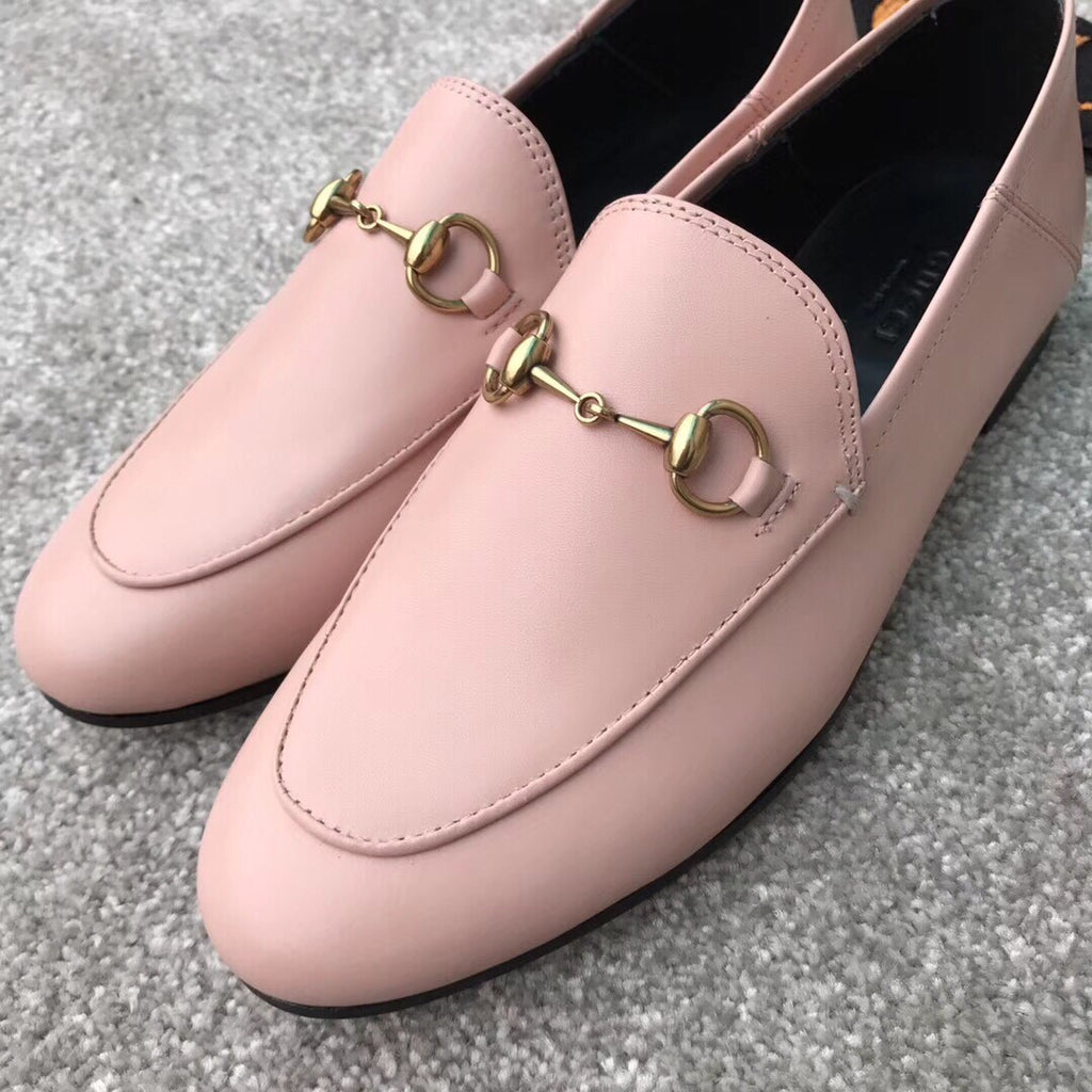 Close-up of pink Gucci loafers with gold-tone bit bar detail and stitched seams