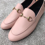 Close-up of pink Gucci loafers with gold-tone bit bar detail and stitched seams