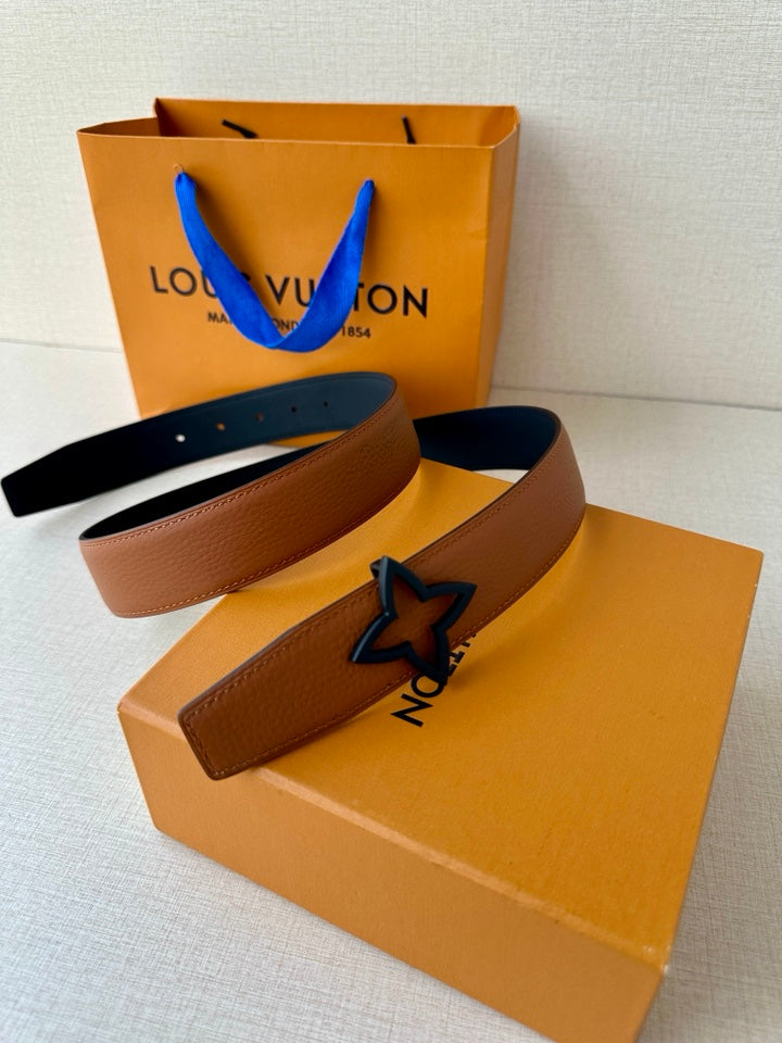 Tan belt with dark navy star buckle, laid across a Louis Vuitton box and pouch