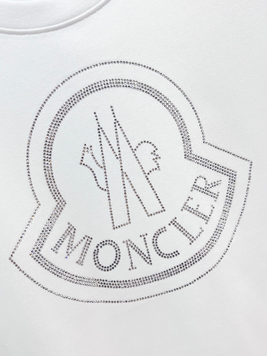 White Moncler T-shirt with large rhinestone heart logo detail.