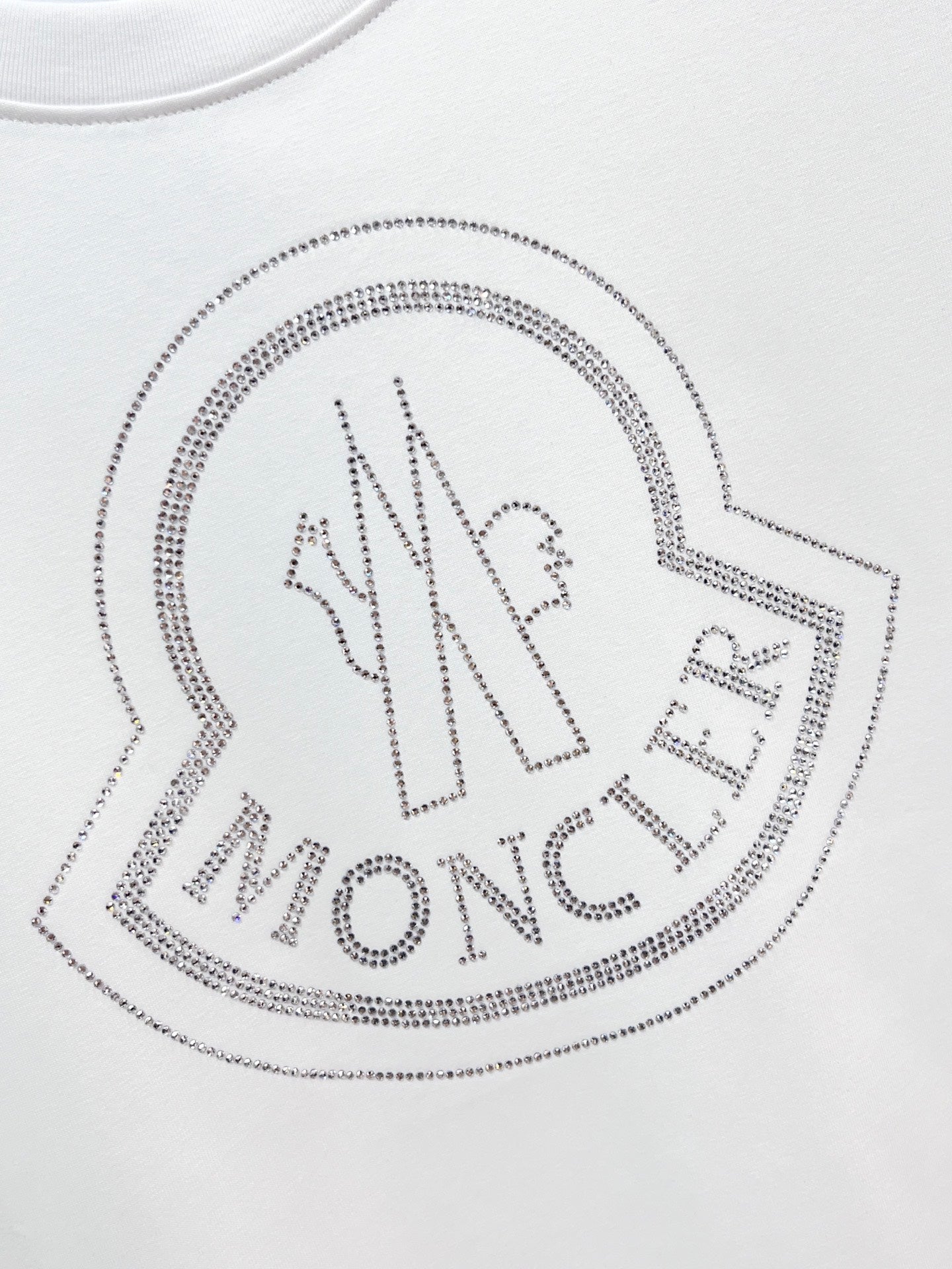 White Moncler T-shirt with large rhinestone heart logo detail.