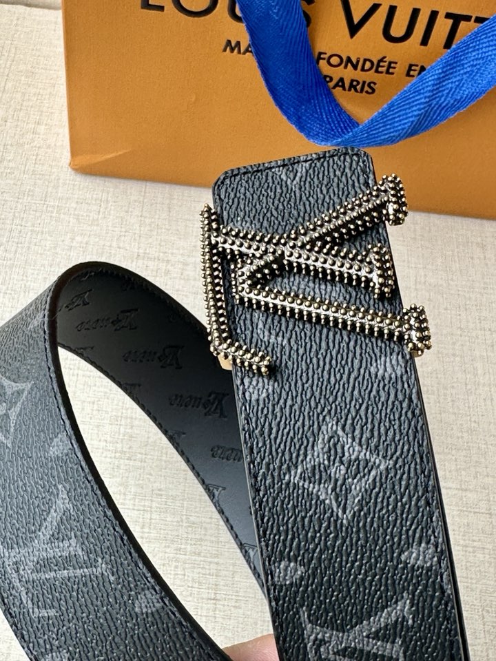 Louis Vuitton belt buckle detail on dark blue monogram strap with silver-tone stones