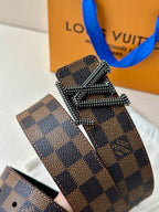 Louis Vuitton belt close-up: dark checkered strap with silver V buckle and studs