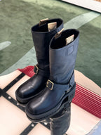Black leather tall boots with two buckled straps and thick rubber tread