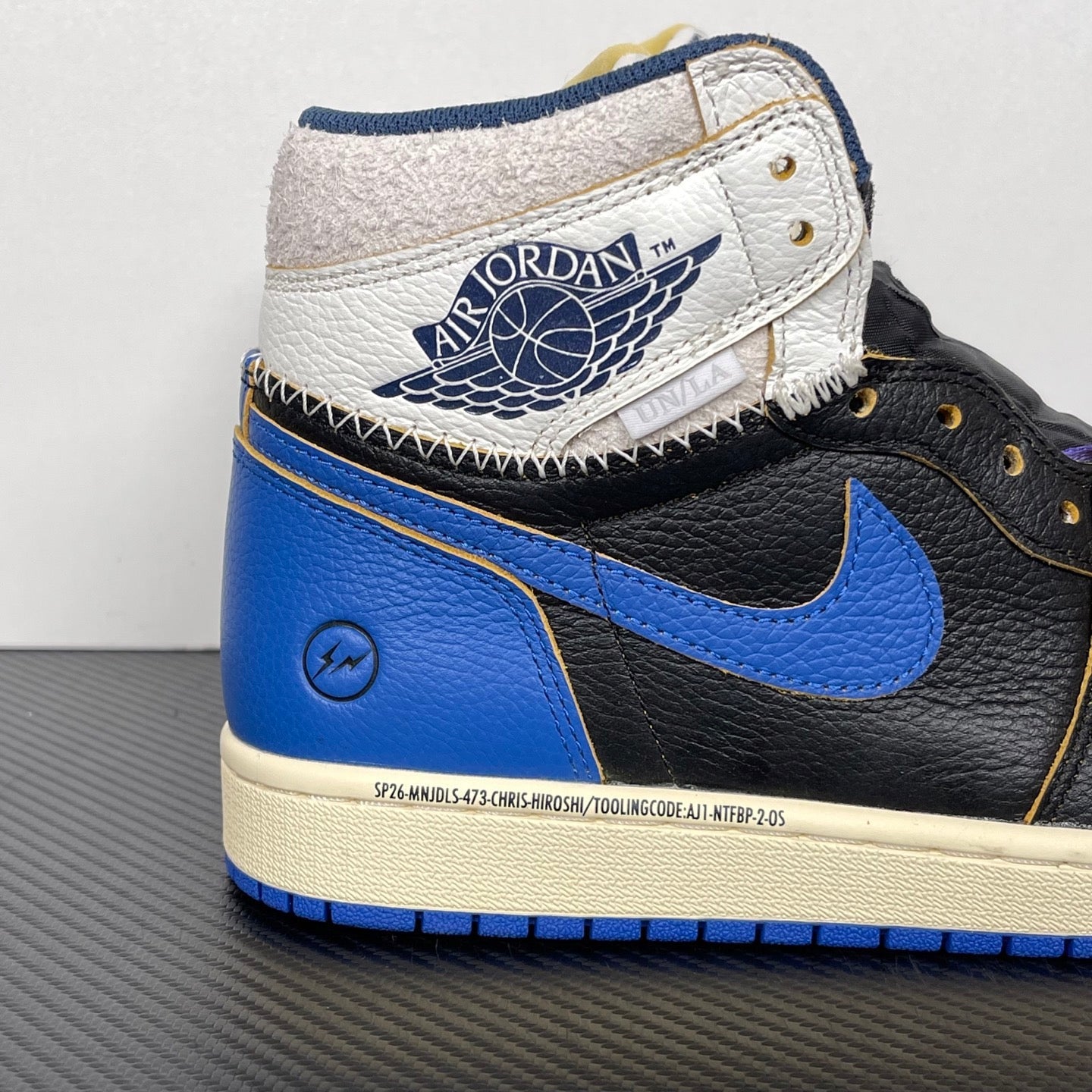 High-top sneakers with white collar panel, black leather and blue swoosh, cream midsole