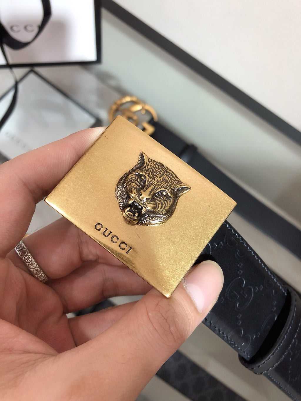 Belt with gold cat-head charm on black strap