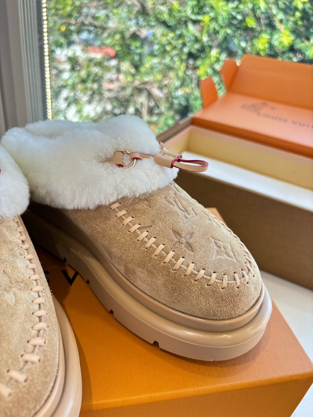 Louis Vuitton tan suede loafer close-up, white fur collar and front strap detail