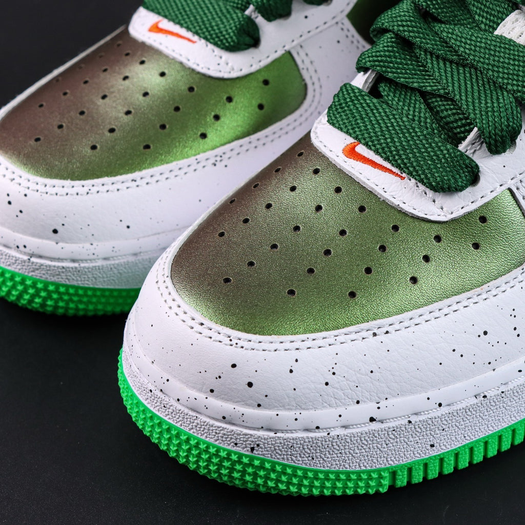 Air Force 1 sneakers, perforated toe with green panels; white laces with orange accents.