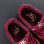 Burgundy sneaker tongues and insoles with gold Nike Air logo, close-up