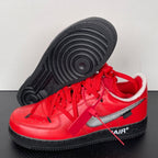 Red low-top sneakers with textured black outsole tread and silver swoosh