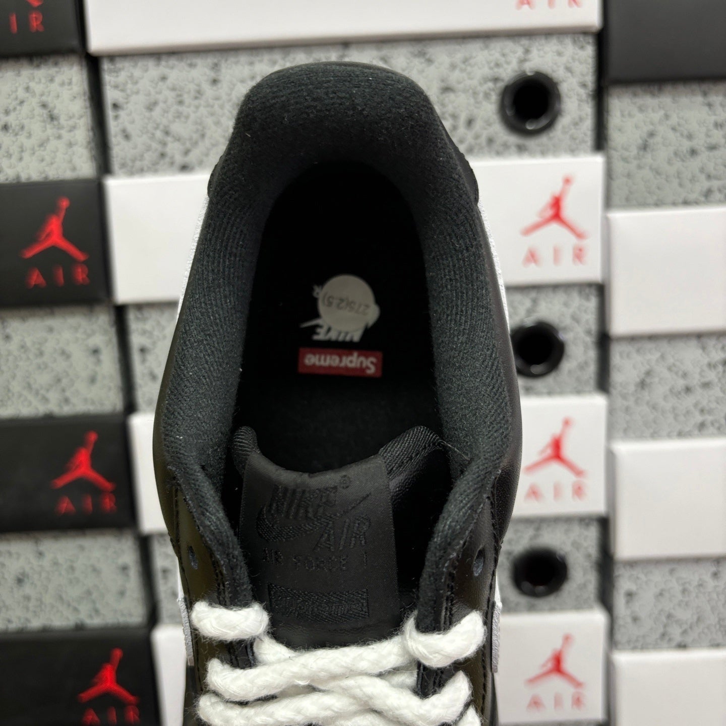 Black low-top sneaker heel with white laces and padded collar