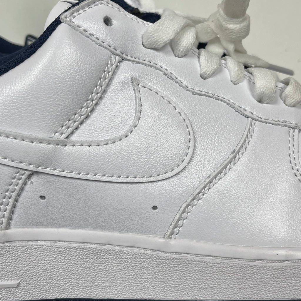 White Nike Air Force 1 side panel with stitched swoosh and lace-up collar