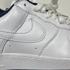 White Nike Air Force 1 side panel with stitched swoosh and lace-up collar
