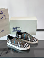 Plaid low-top sneakers pair, lace-up with black trim and blue accents on box