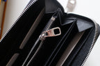 Small Louis Vuitton zip wallet open with zipper pull and multiple card slots visible.