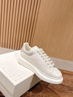 Alexander McQueen leather sneakers, white, angled side view on display box