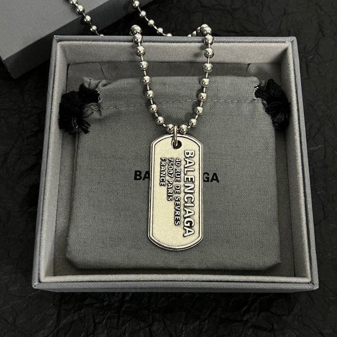 Silver-tone bead dog tag necklace displayed in box with pendant