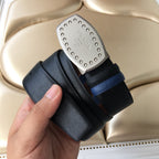 Navy belt with silver studded Prada buckle and black-and-blue strap layers