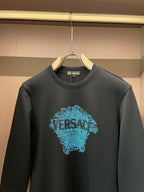 Black crewneck sweatshirt close-up: blue text face graphic and neck seam