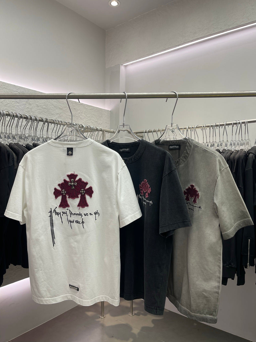 White short-sleeve T-shirt with pink cross embroidery and white script details