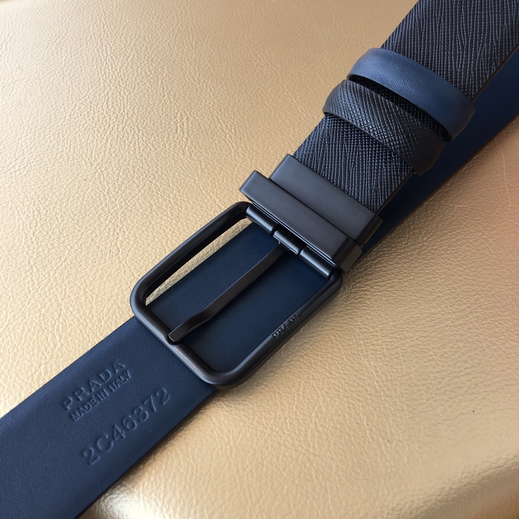 Navy belt buckle and keeper with embossed Prada lettering on strap.