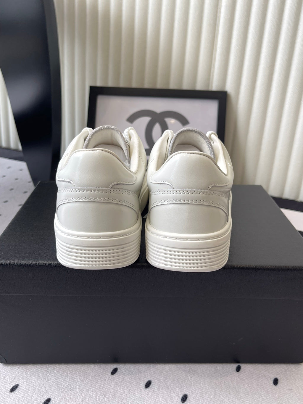 White leather sneakers, rear view with cushioned collar and stitching