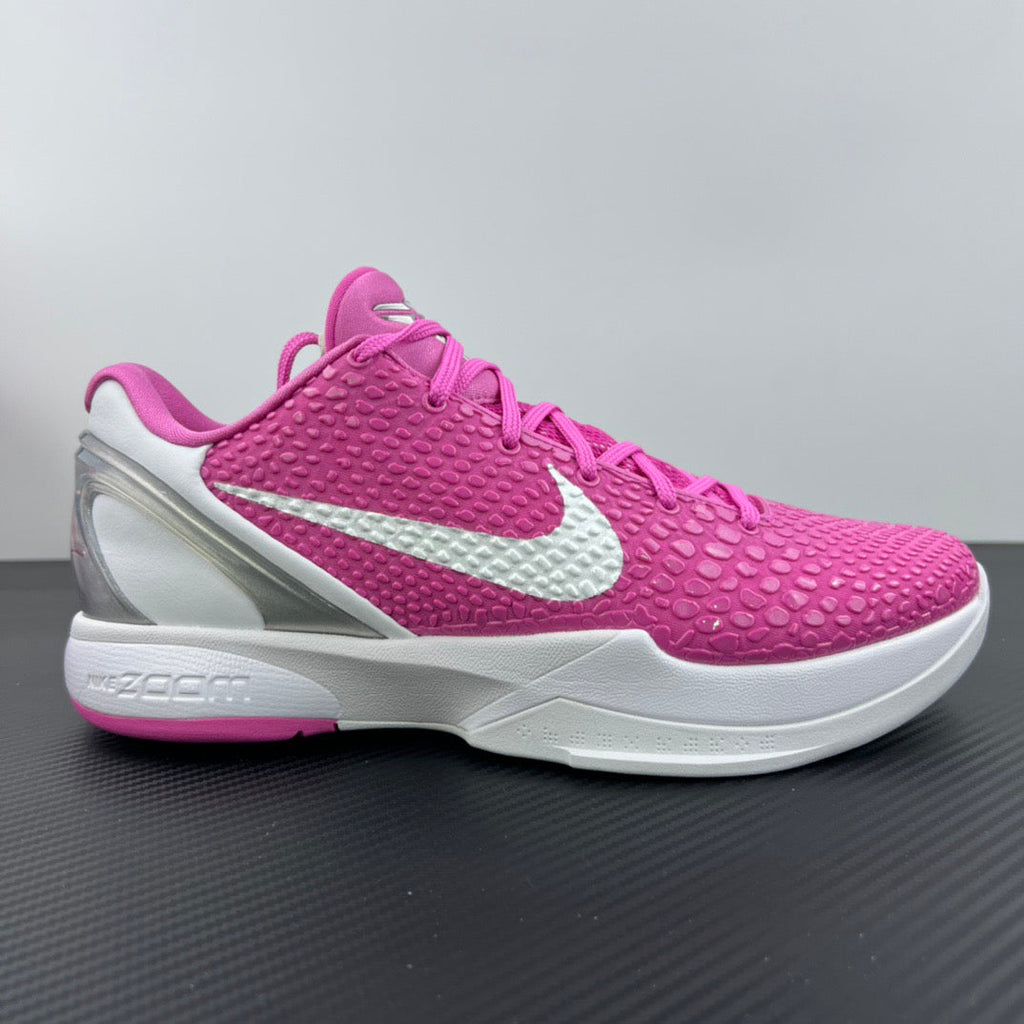 Pink and white low-top basketball sneaker with white swoosh and padded collar
