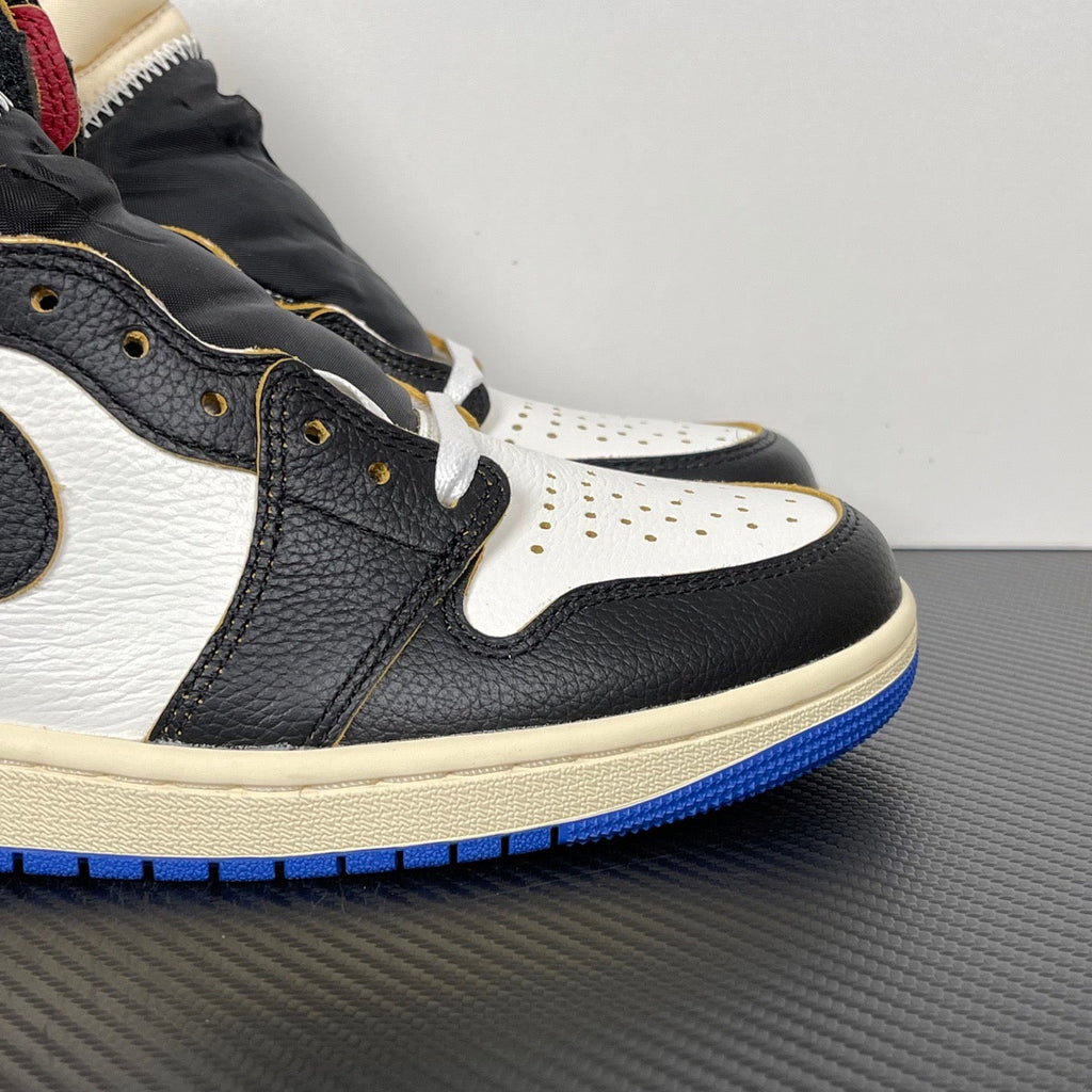 High-top sneaker close-up, black and white leather with blue outsole and gold eyelets