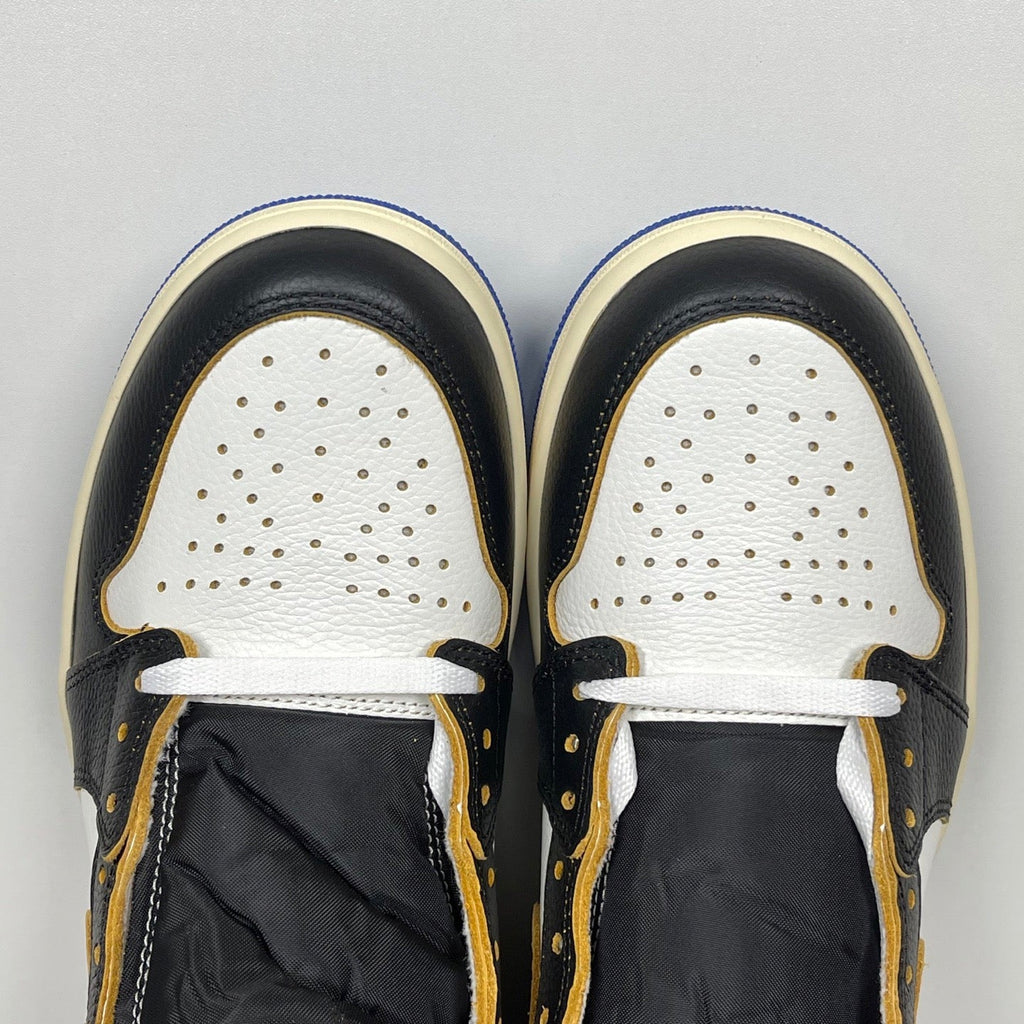 High-top sneaker toe view: white perforated toe box, black panels, white laces, cream trim