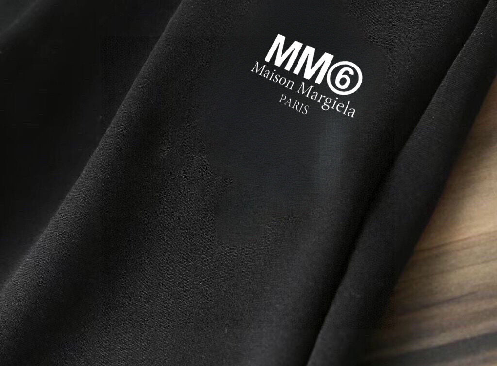 Black hoodie sleeve close-up with MM6 Maison Margiela logo lettering