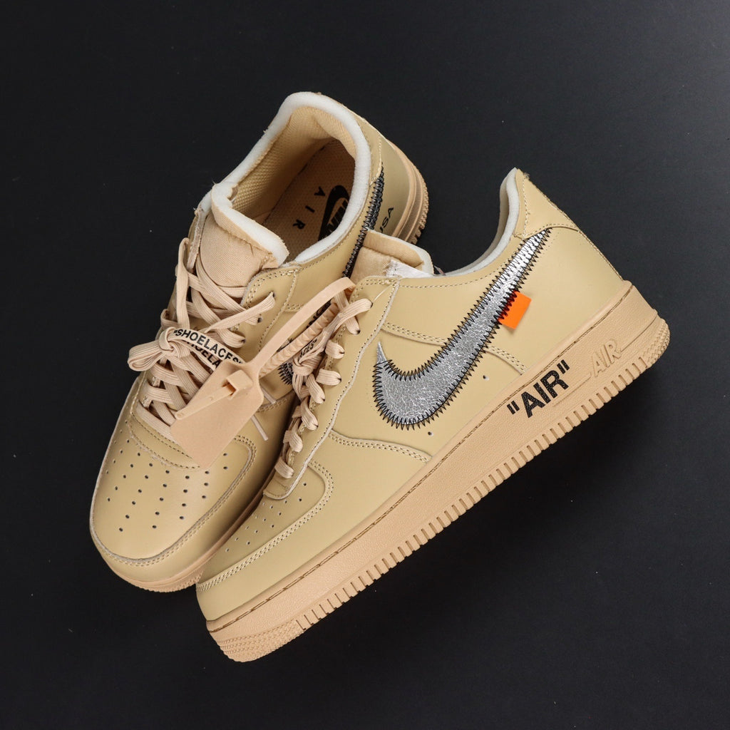 Pair of cream Air Force 1 low-top sneakers with blue Nike swoosh and gum sole