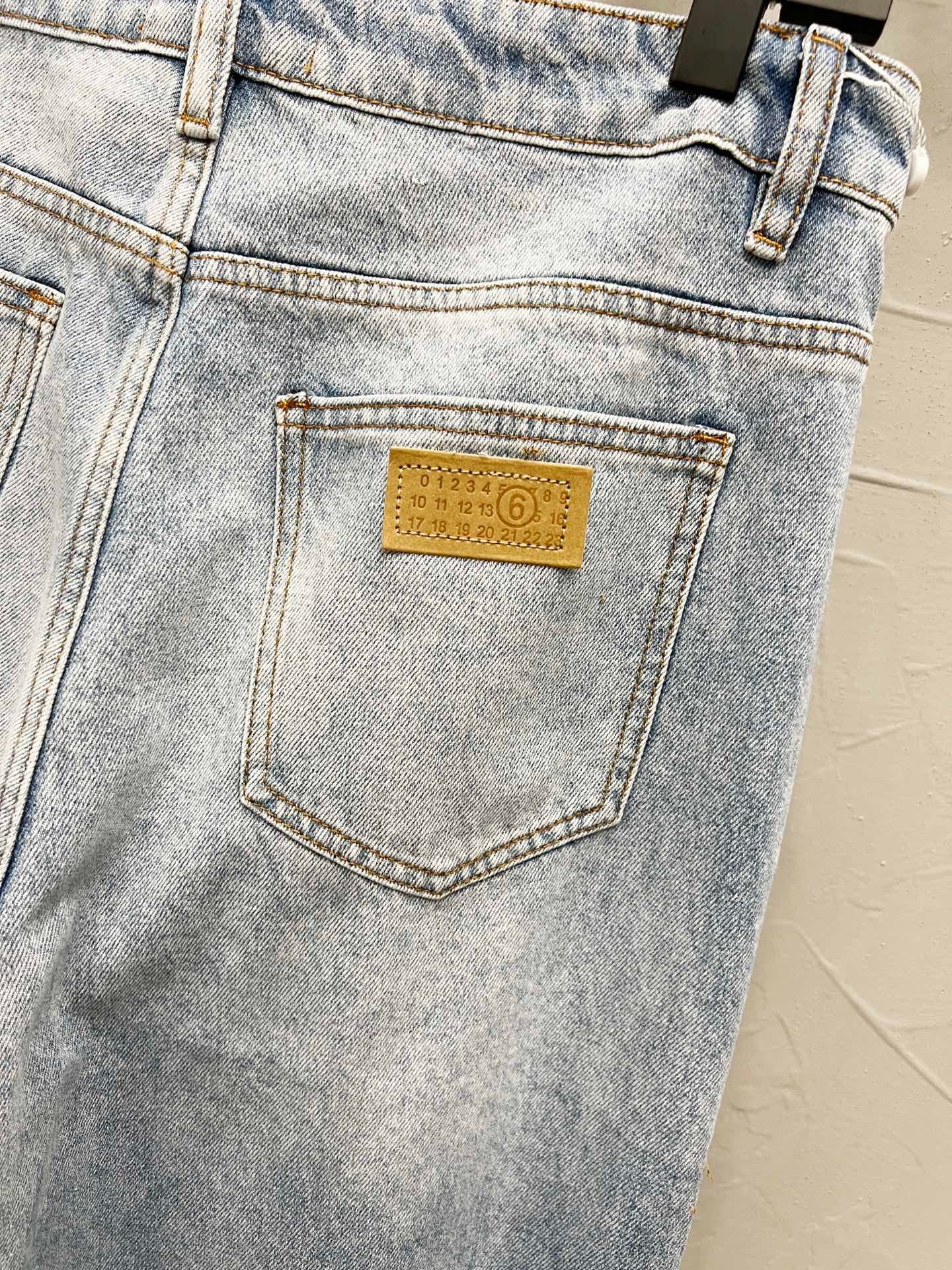 Maison Margiela denim jeans back pocket close-up with yellow rectangular logo label