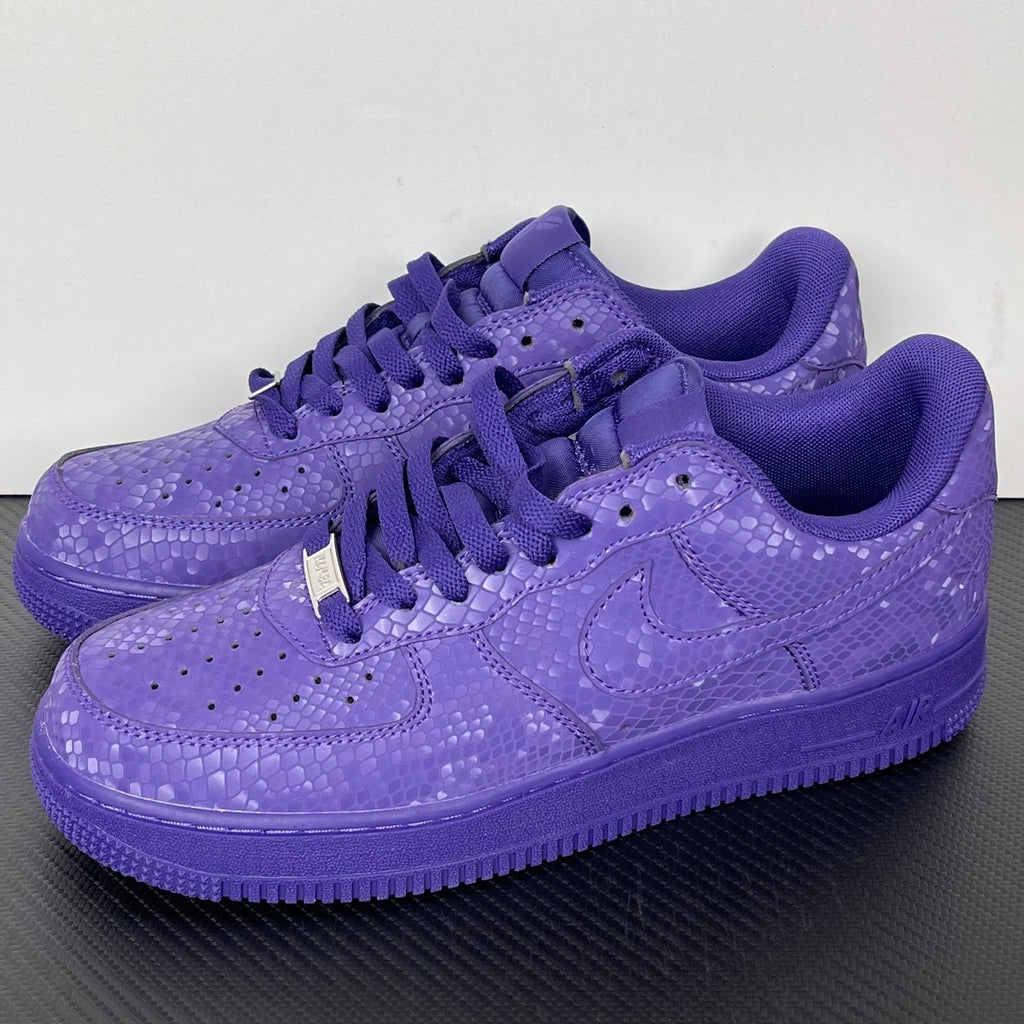 Pair of purple low-top sneakers with lace-up closure and embossed pattern