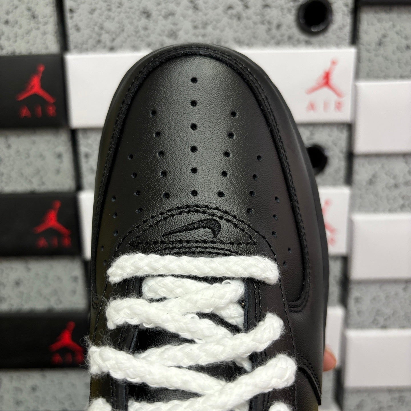 Black sneaker toe box with perforations and white lace detailing