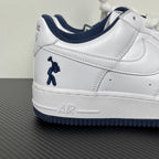 White Nike Air Force 1 low-top sneaker with navy swoosh and lace-up detail