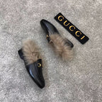 Gucci black loafer with faux fur cuff and gold bit hardware, angled view