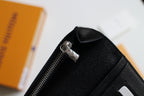Louis Vuitton small wallet zipper pull on black leather, open edge visible