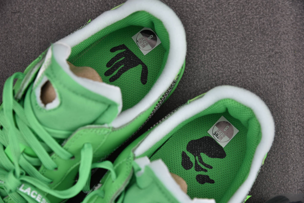 Pair of green low-top sneakers with white soles and black logo on tongues