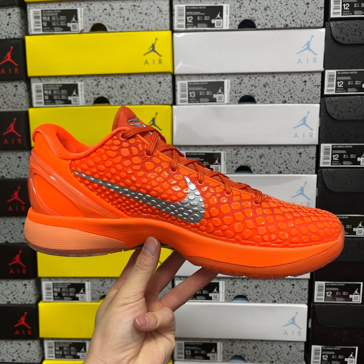 Orange lace-up athletic sneaker with textured upper and gray swoosh