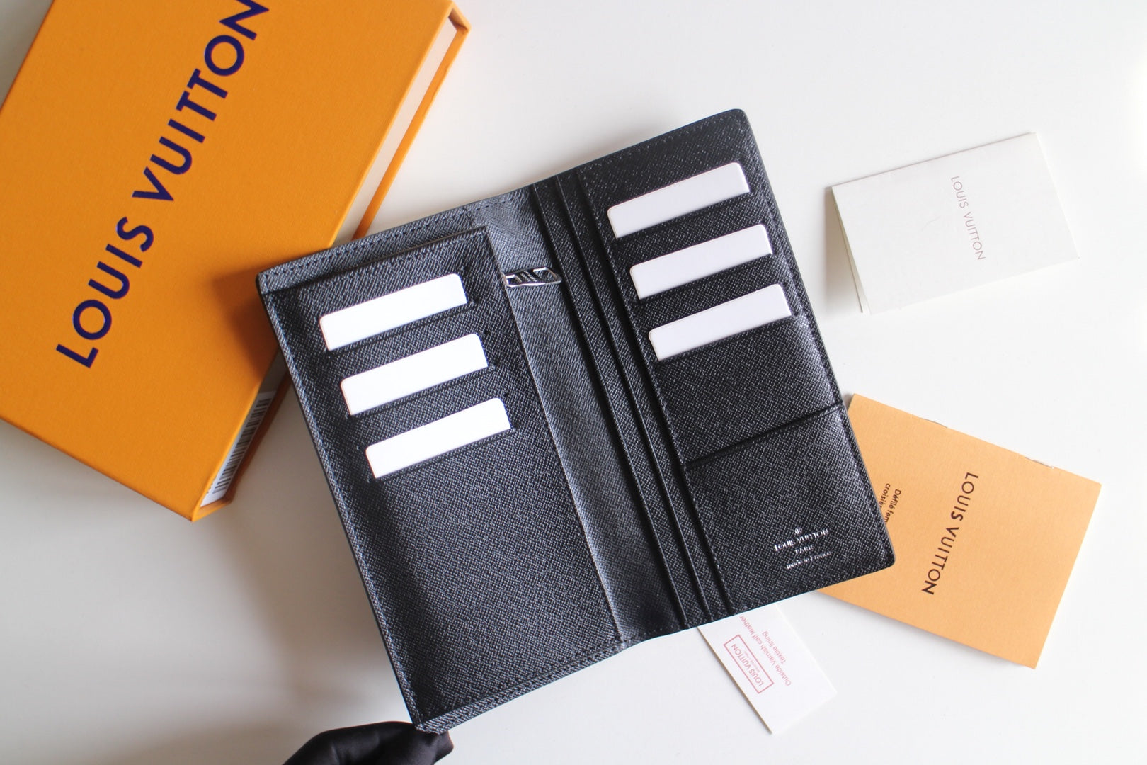 Small Louis Vuitton black textured cardholder open, showing multiple card slots