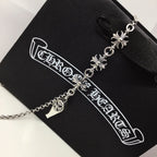 Silver chain necklace with fleur-de-lis and lock charm, on black card