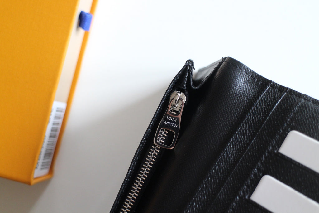 Small Louis Vuitton black textured cardholder with zipper opening and LV tag