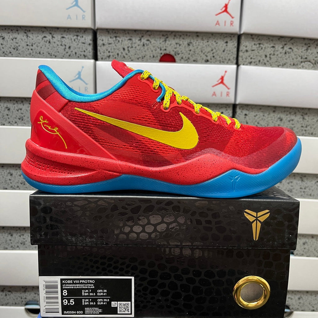 Red basketball shoe with yellow swoosh, blue sole, and lace-up front.