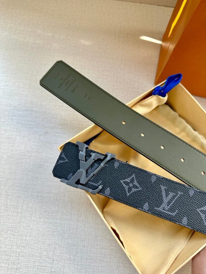 Louis Vuitton belt laid flat with dark monogram strap, perforated holes, and silver buckle.