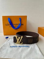 Dark monogram belt with gold rhinestone buckle centered on the strap.
